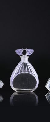 three clear glass perfume bottles sitting on top of a black surface