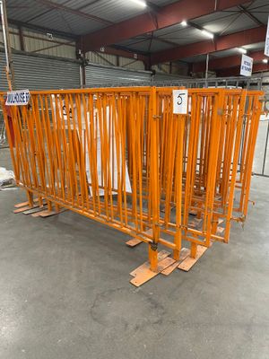 un grand nombre de barrières métalliques orange dans un entrepôt
