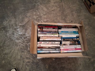 une boîte remplie de DVD posée par terre