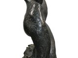 statue of a woman standing on a rock with her back to the camera