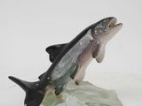 figurine of a fish on a rock on a white surface
