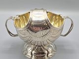 an antique silver plated bowl with handles on a stand