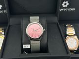 a pink watch in a black box with two other watches