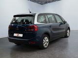 the back of a small blue car parked in a room