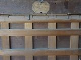 an old wooden door with a metal handle and a plaque on it