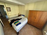a bedroom with a bed, cupboard, and mirror in it
