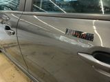 a silver car with a sticker on the side of it