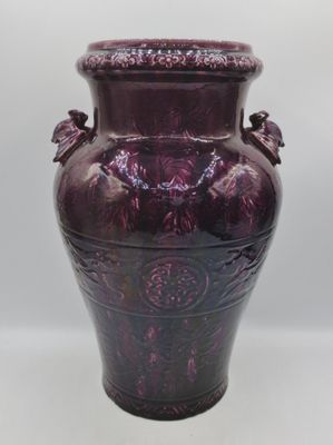 un vase violet posé sur une table blanche