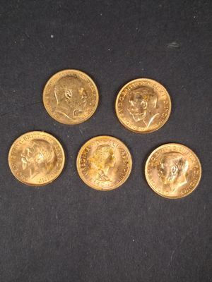quatre types différents de pièces d'or sur une surface noire