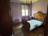 une chambre à coucher avec un lit, une chaise et un lustre