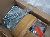 a cardboard box with a bunch of screws and other items in it