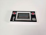 a black and white game console sitting on a white surface