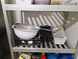 a metal shelf with a bowl and a pan on it