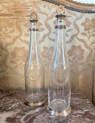 two empty glass bottles sitting on a marble table
