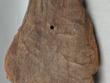 an old wooden object hanging on a wall next to a white wall
