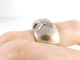 a person ' s hand holding a silver ring with a diamond on it