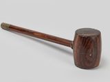 an old pipe with a wooden handle sitting on top of a table