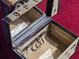 a suitcase with a ring inside of it on a red surface