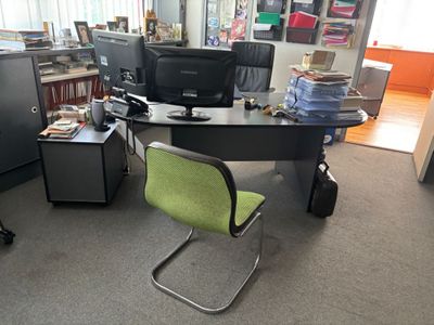 un bureau avec un ordinateur et une chaise dans une pièce