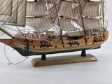 a wooden model of a sailing ship on a stand