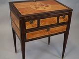 une petite table en bois avec des tiroirs, sur laquelle sont posés d'autres tiroirs