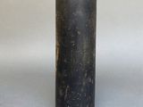 a black vase with a silver rim on a gray surface