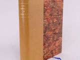 an old book sitting on top of a white surface next to a blue ribbon