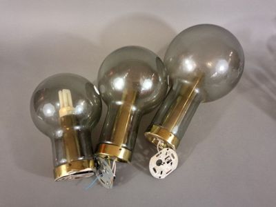 three light bulbs on a table with a white background