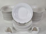 a lot of white plates and cups on the table