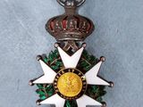 a silver and gold medal with a crown on it