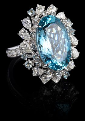 un gros plan d'une bague ornée d'une grosse pierre bleue entourée de diamants