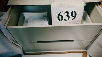 une boîte sur laquelle est inscrit un numéro, posée sur un lit