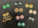 several pairs of earrings are displayed on a black surface
