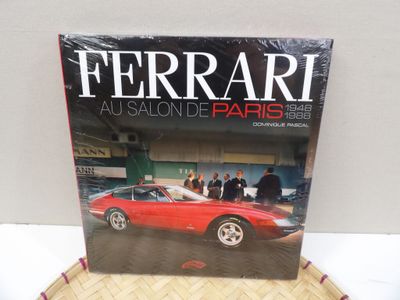 a red ferrari book sitting on top of a wooden table