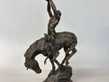 statue en bronze représentant un homme sur un cheval qui rue, tenant un oiseau