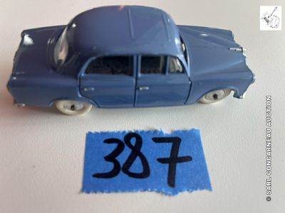 une petite voiture bleue posée sur une feuille de papier bleue