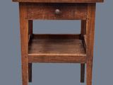 une vieille table en bois avec un tiroir en dessous, sur fond gris