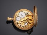 an antique pocket watch on a black surface with a black background