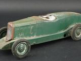 a green toy car that is sitting on a black surface