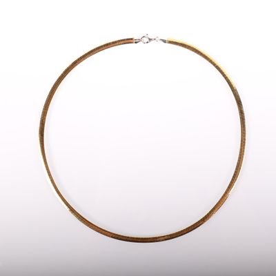 gros plan d'un collier en or sur fond blanc
