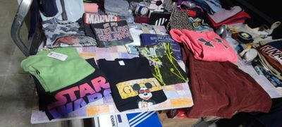 a pile of t - shirts and other items on a table