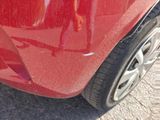 a close up of a red car that has been dented