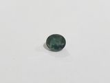 a close up of a green sapphire stone on a white surface