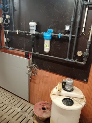 a bathroom with a toilet and a water heater on the wall