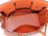the inside of a brown purse with a strap on it