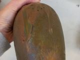 a person holding a brown vase with a tag on it