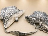 two pieces of silver on display in a display case