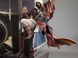 statue of a man sitting on top of a boat holding a sword