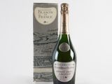 a bottle of champagne next to a box of wine