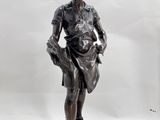 bronze statue of a boy holding a basket on a marble base